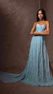 homme avec manteau beige, dessus à col roulé transparent en plastique avec des paillettes sur le torse. Paillettes sur le visage.